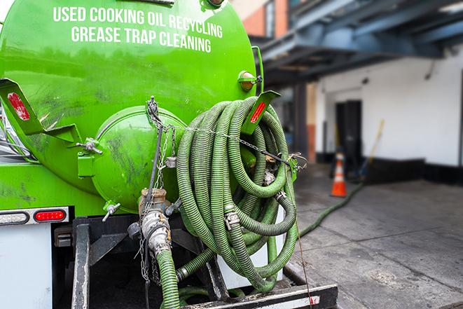 a grease trap being pumped by a sanitation technician in Hainesville, IL